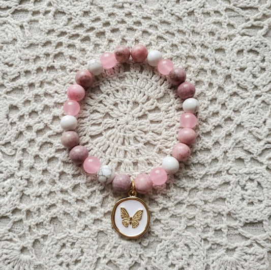 Beaded bracelet with a butterfly charm on a lace background