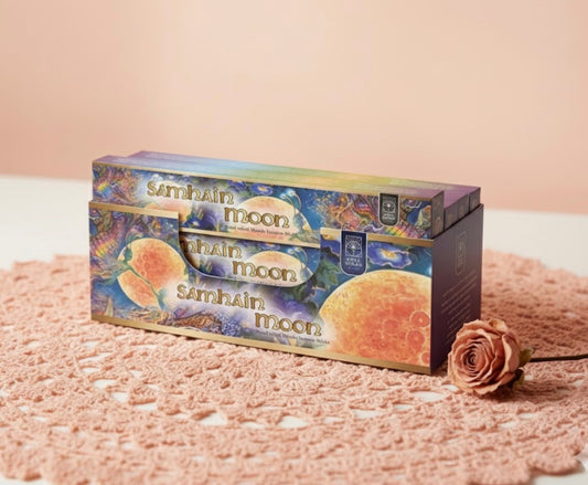 Samhain moon product packaging on a textured surface with a rose.