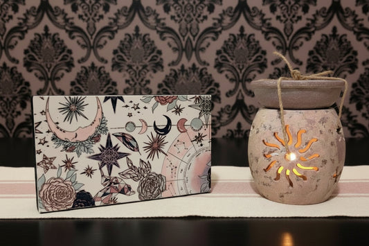 Aromatherapy soapstone for oils and incense holder with celestial design on a wooden surface.