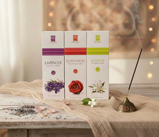 Three boxes of incense labeled 'Lavender', 'Dutch Rose', and 'Jasmine' on a wooden surface with decorative elements.