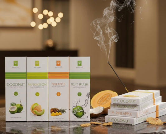 Packaging of fruit and coconut-flavored incense with incense and fruit on a reflective surface.