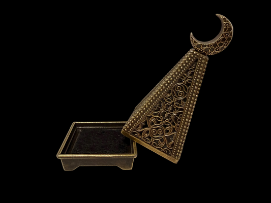 Decorative bronze incense cone holder with a crescent moon design on a black background