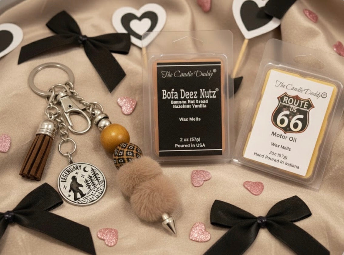 Two wax tarts labeled 'Bofa Deez Nutz' and 'Route 66 Motor Oil' with decorative keychain and small items on a textured surface.