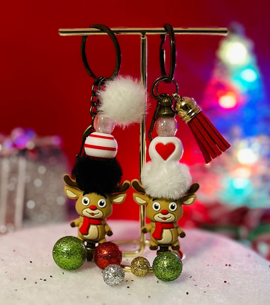 reindeer keychains with decorative elements on a stand against a festive background.