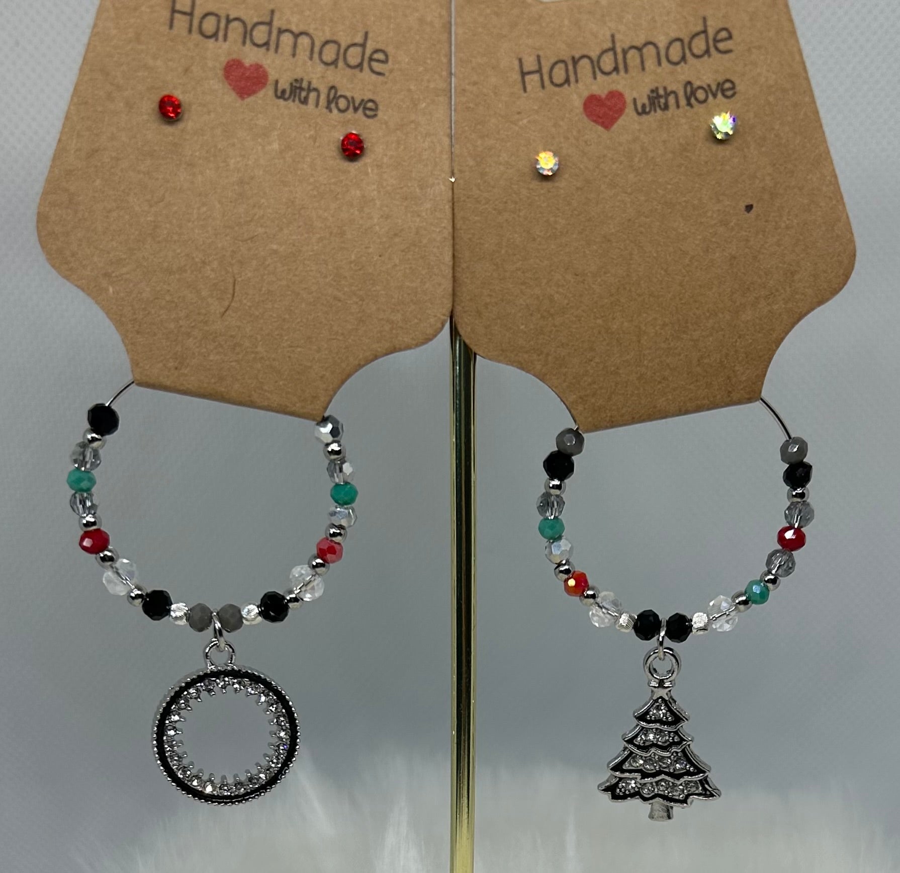 Beaded wine glass charms on a display stand with 'Handmade with Love' tags. Christmas. Holiday wine glass charms. 