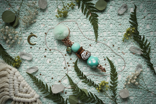 Pot Head Keychain with turquoise beads and greenery on a marble surface