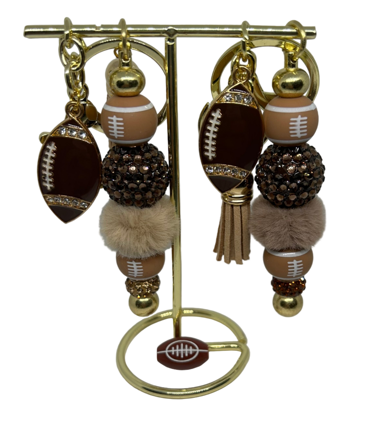 Decorative stand with football-themed keychain and shiny beads and charms on a white background. 