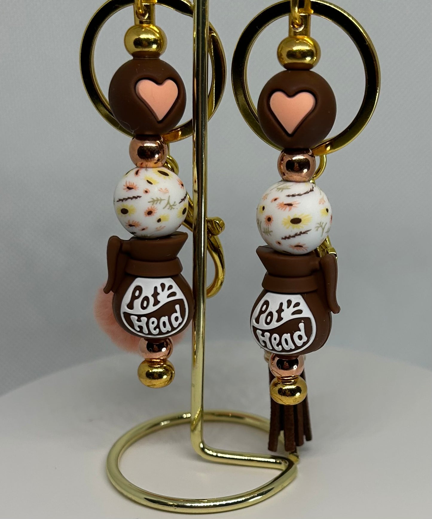 Pot head keychain bag charm in pink and brown and white beads on a gold stand
