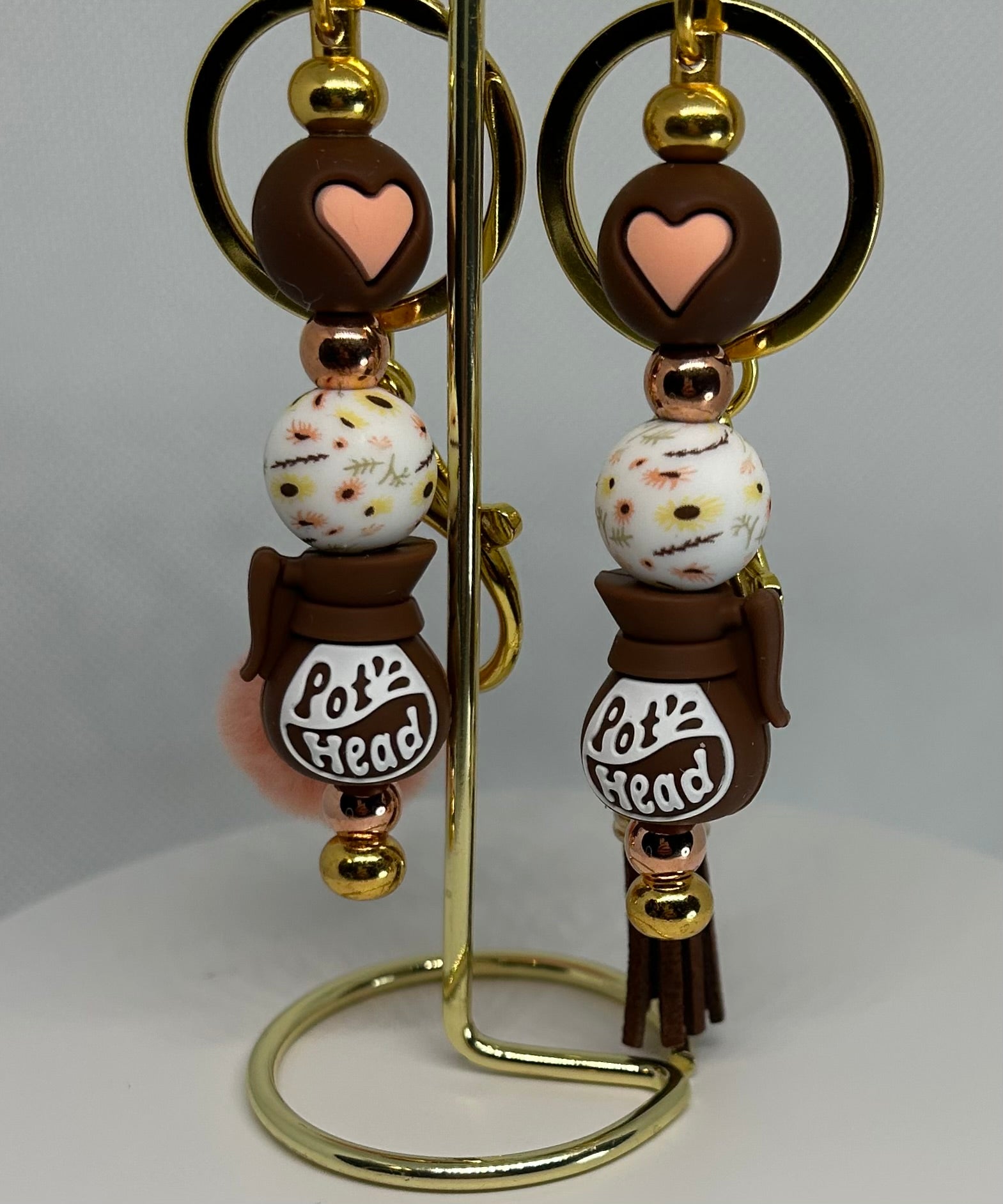 Pot head keychain bag charm in pink and brown and white beads on a gold stand