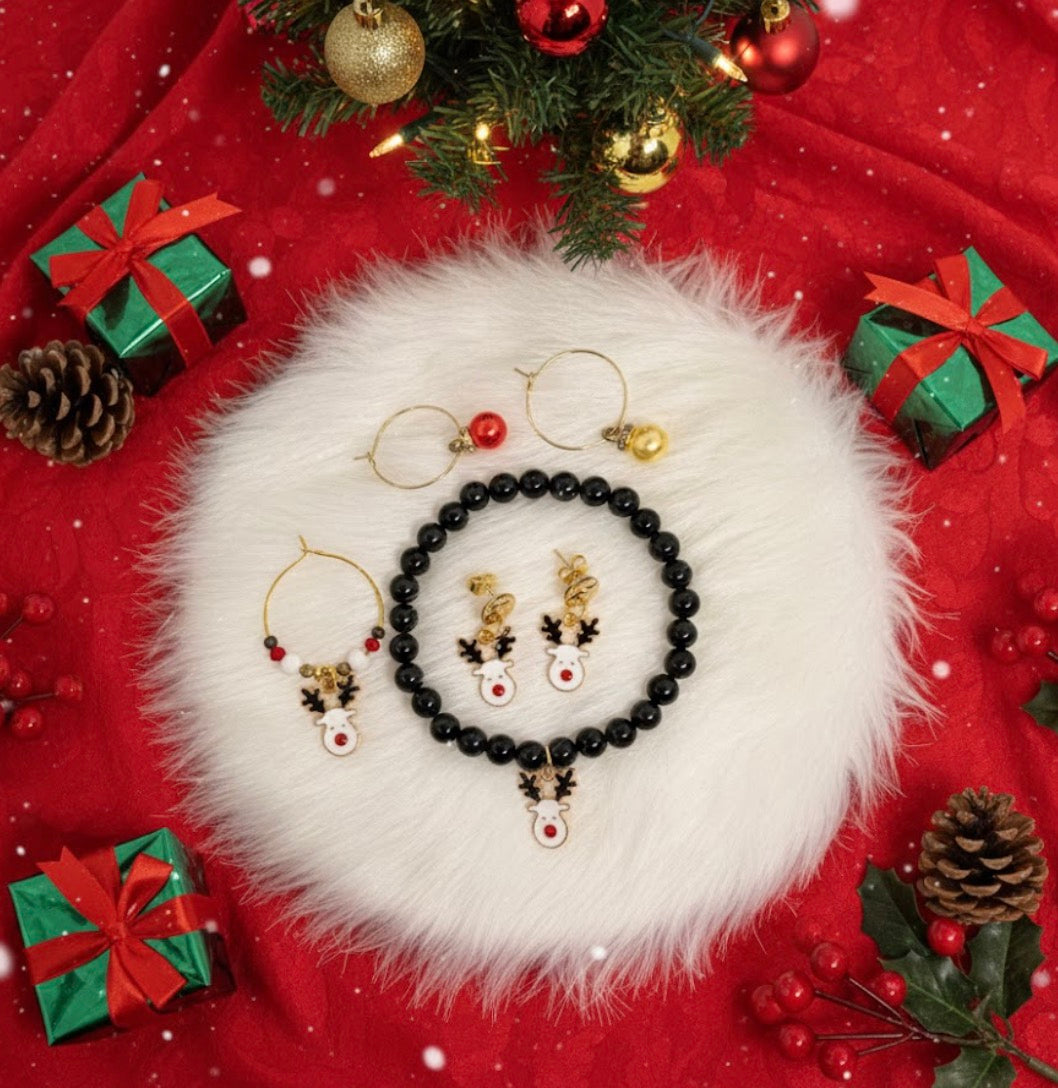 Reindeer jewelry set on a white fur surface with Christmas decorations including gift boxes and a tree. Gold accents and black onyx. 