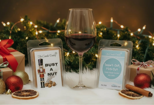 Wine glass with Christmas decorations and wax melts that say snow's out ho's out and bust a nut. 