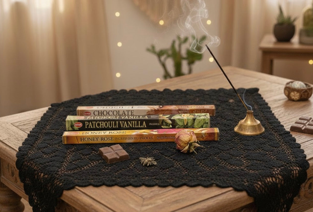 Honey, patchouli, and chocolate Incense sticks with various scents on a black lace tablecloth with a blurred background