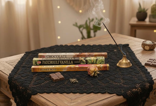Honey, patchouli, and chocolate Incense sticks with various scents on a black lace tablecloth with a blurred background