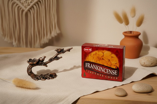 Bronze bird incense cone holder and HEM frankincense incense cones packaging on a white background