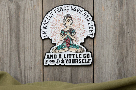 Pin with text and a design of a person in a meditative pose on a wooden surface