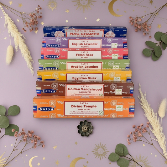 Stack of Satya incense boxes on a decorative background with flowers and herbs.