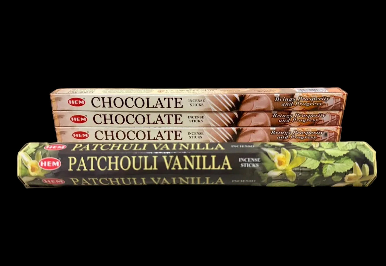 Two packages of HEM incense sticks, one labeled 'Chocolate' and the other 'Patchouli Vanilla', on a black background.