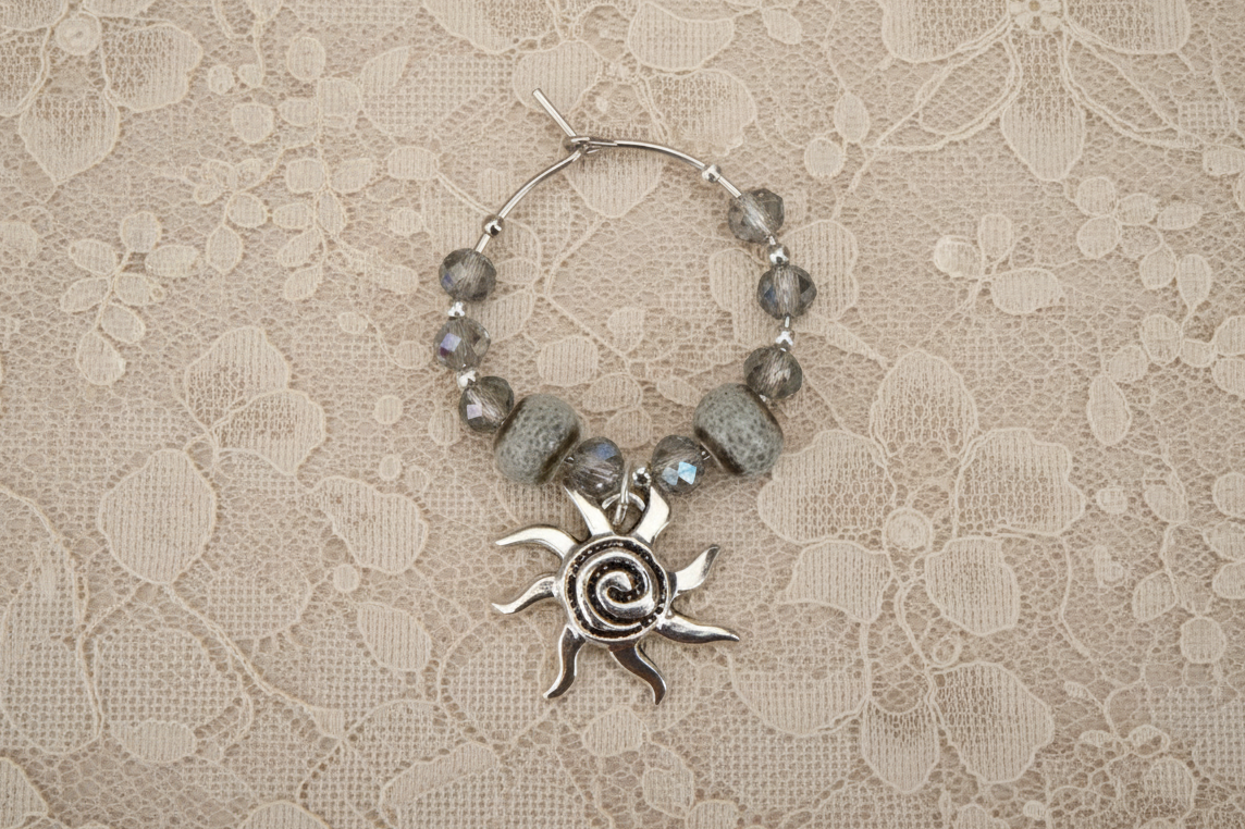 Silver sun charm with beads on a lace background