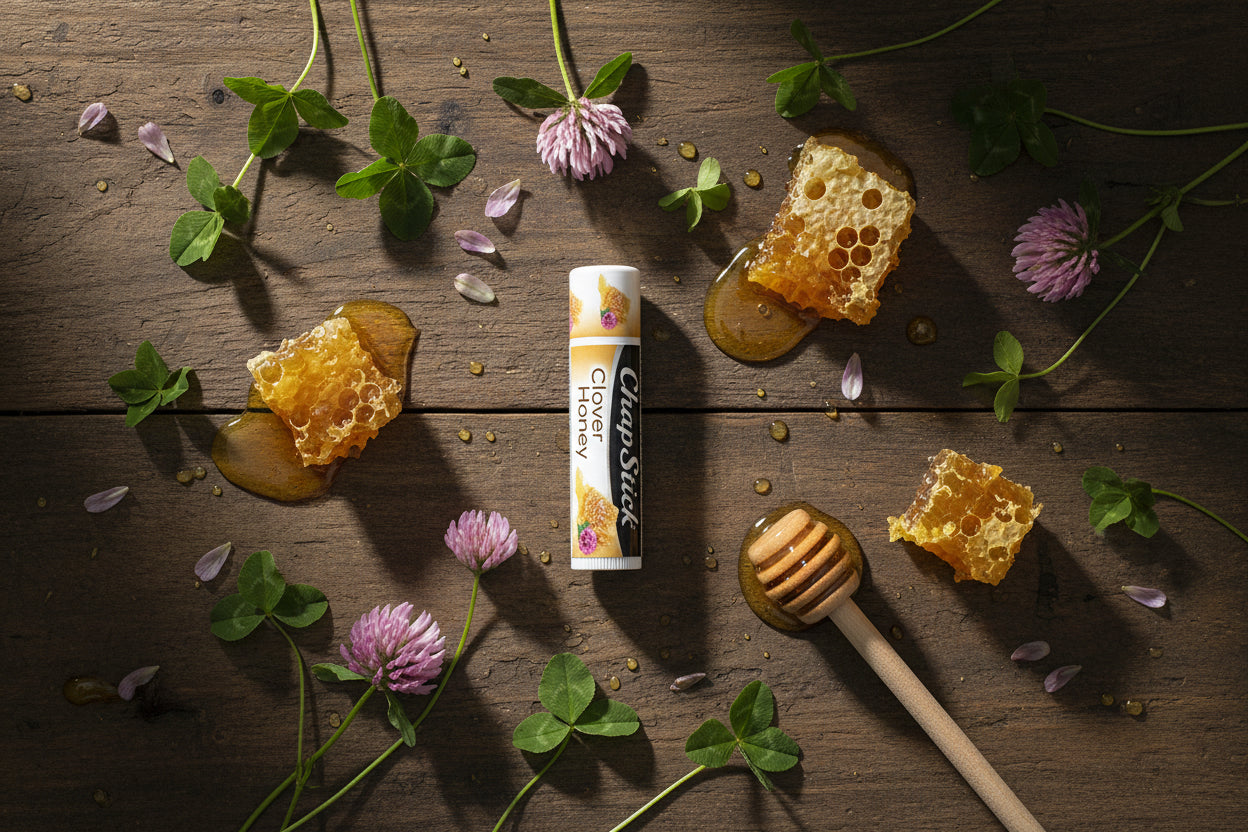 Chapstick honey clover lip balm on a wooden surface with honeycombs and flowers
