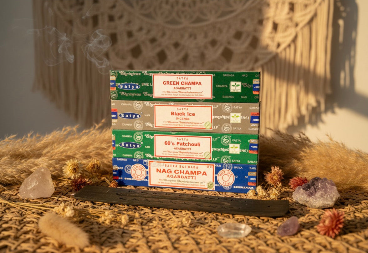 Collection of Nag Champa incense boxes on a textured surface with decorative elements.