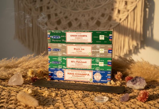 Collection of Nag Champa incense boxes on a textured surface with decorative elements.