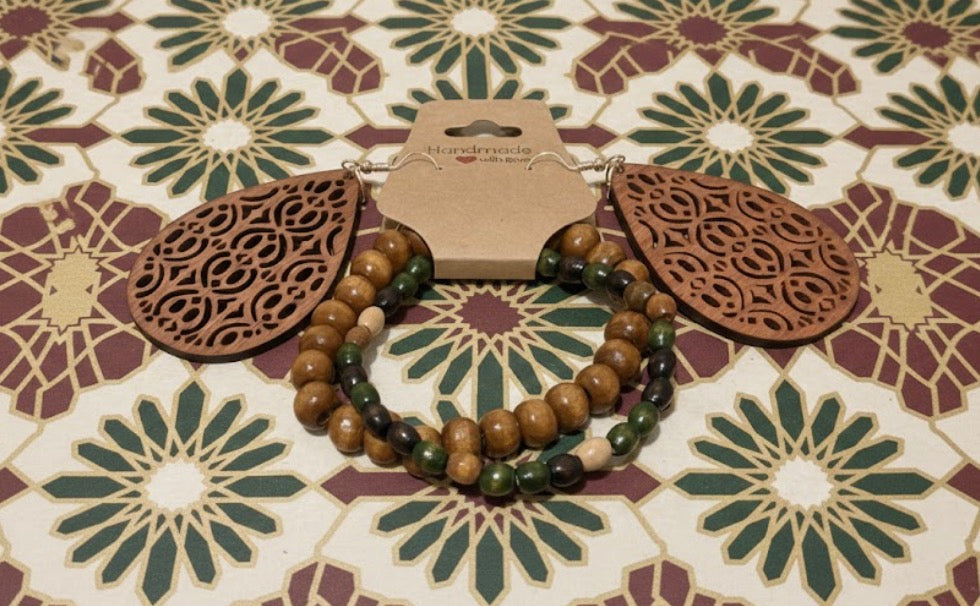 Wooden jewelry set with beaded bracelet and earrings on a patterned surface