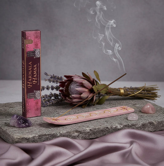 Incense stick box, incense sticks, and decorative elements on a stone surface with a gray background. Harmala Hamsa