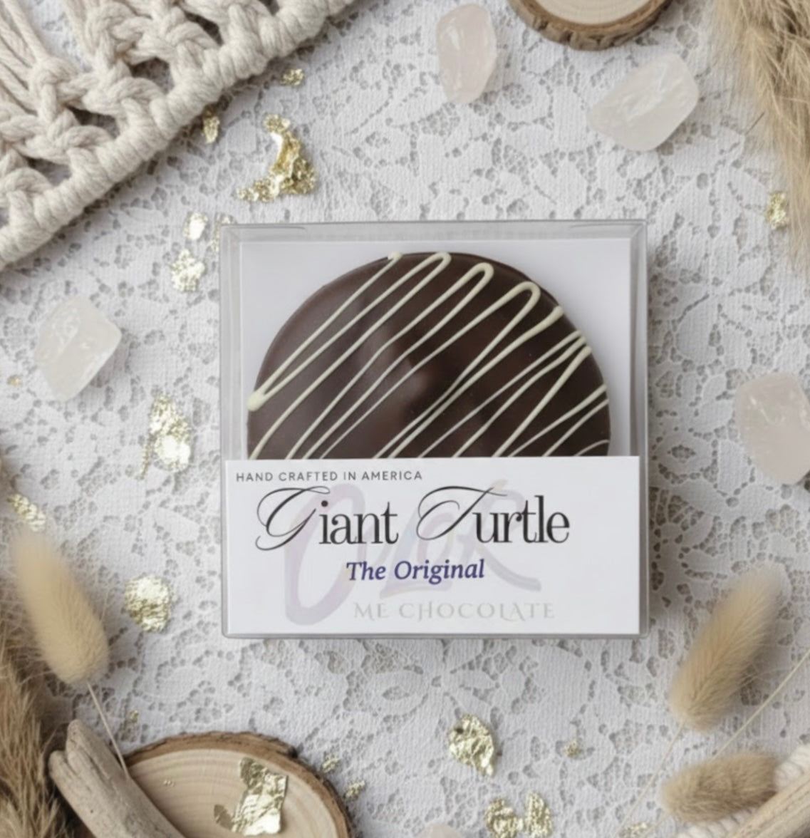 Chocolate turtle candy in a box labeled 'Giant Turtle' on a textured surface with decorative elements.
