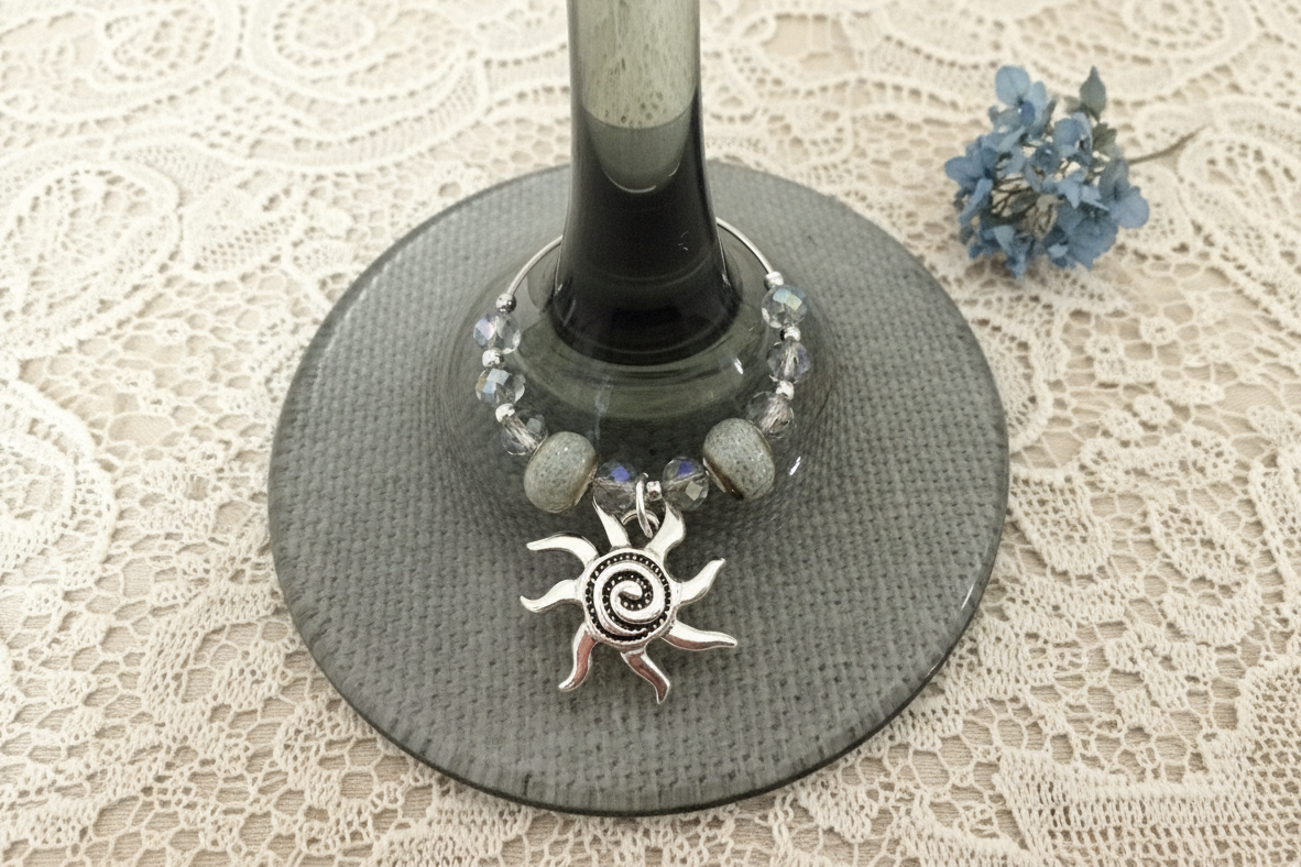 Wine glass with decorative charm on a lace tablecloth