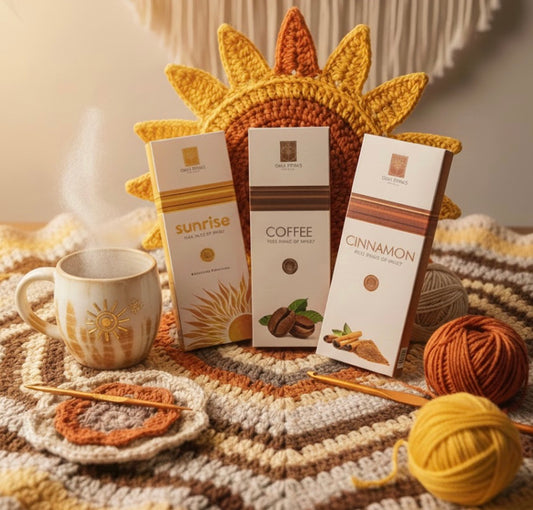Coffee packages and a mug on a textured surface with yarn and knitting needles.
