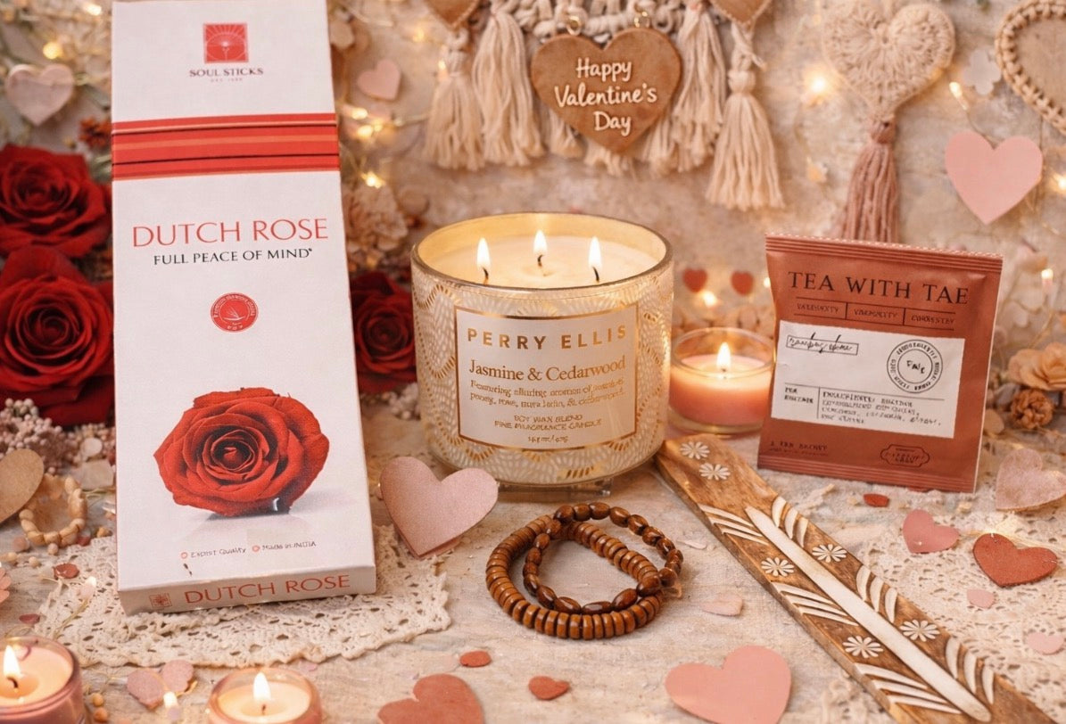 Candle, tea with Tae tea, incense, jewelry, incense burner and decorative items on a table with 'Happy Valentine's Day' sign.
