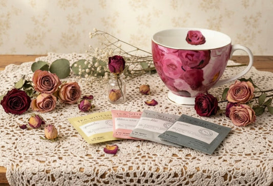 Teacup with floral design on a tablecloth with flowers and cards