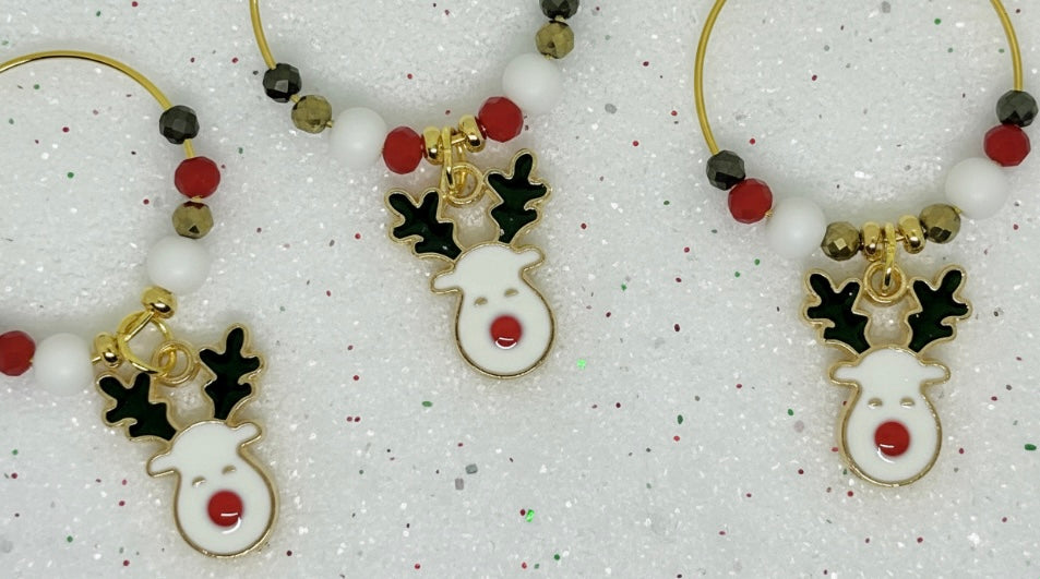 Decorative reindeer wine glass charm with gold, red, and black beads on a white background.