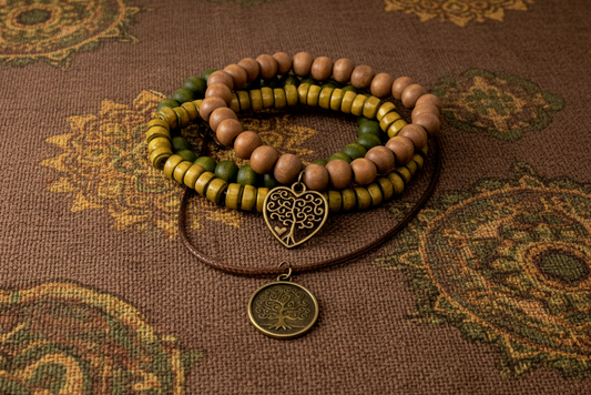 Stack of beaded bracelets with a heart-shaped treecharm on a patterned fabric background