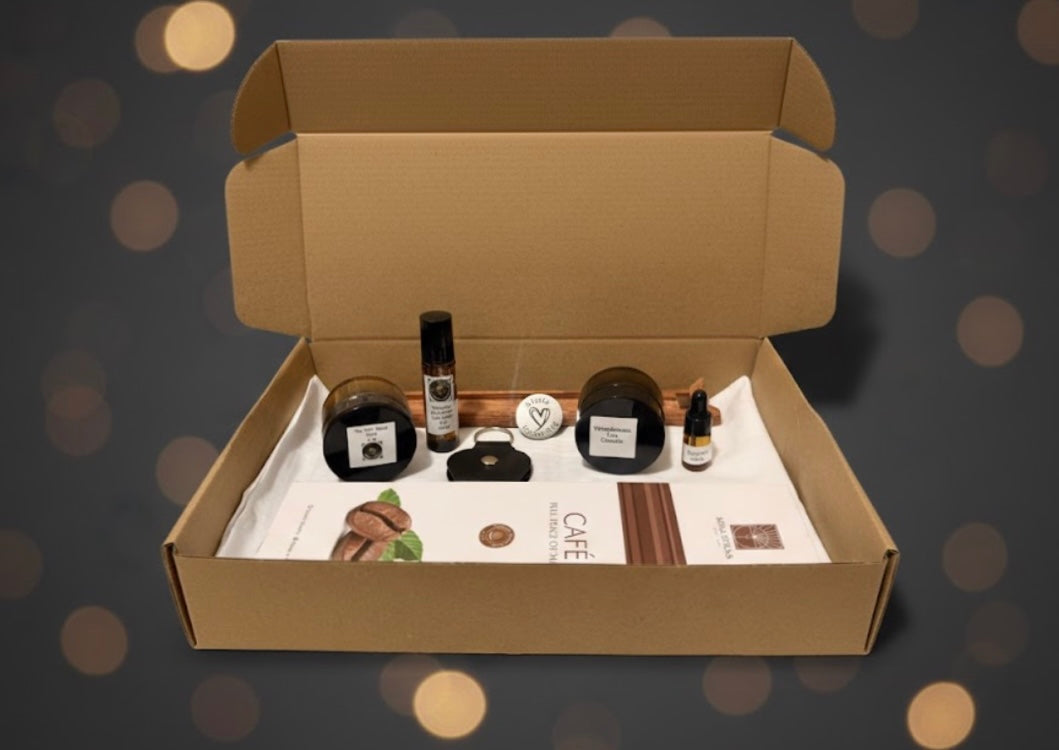 Open cardboard box containing various fragrance items on a dark background with bokeh effect