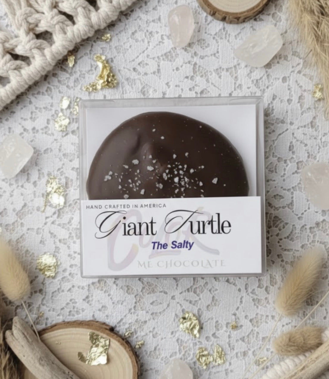 Chocolate turtle candy in a box with 'Giant Turtle' branding on a decorative surface.