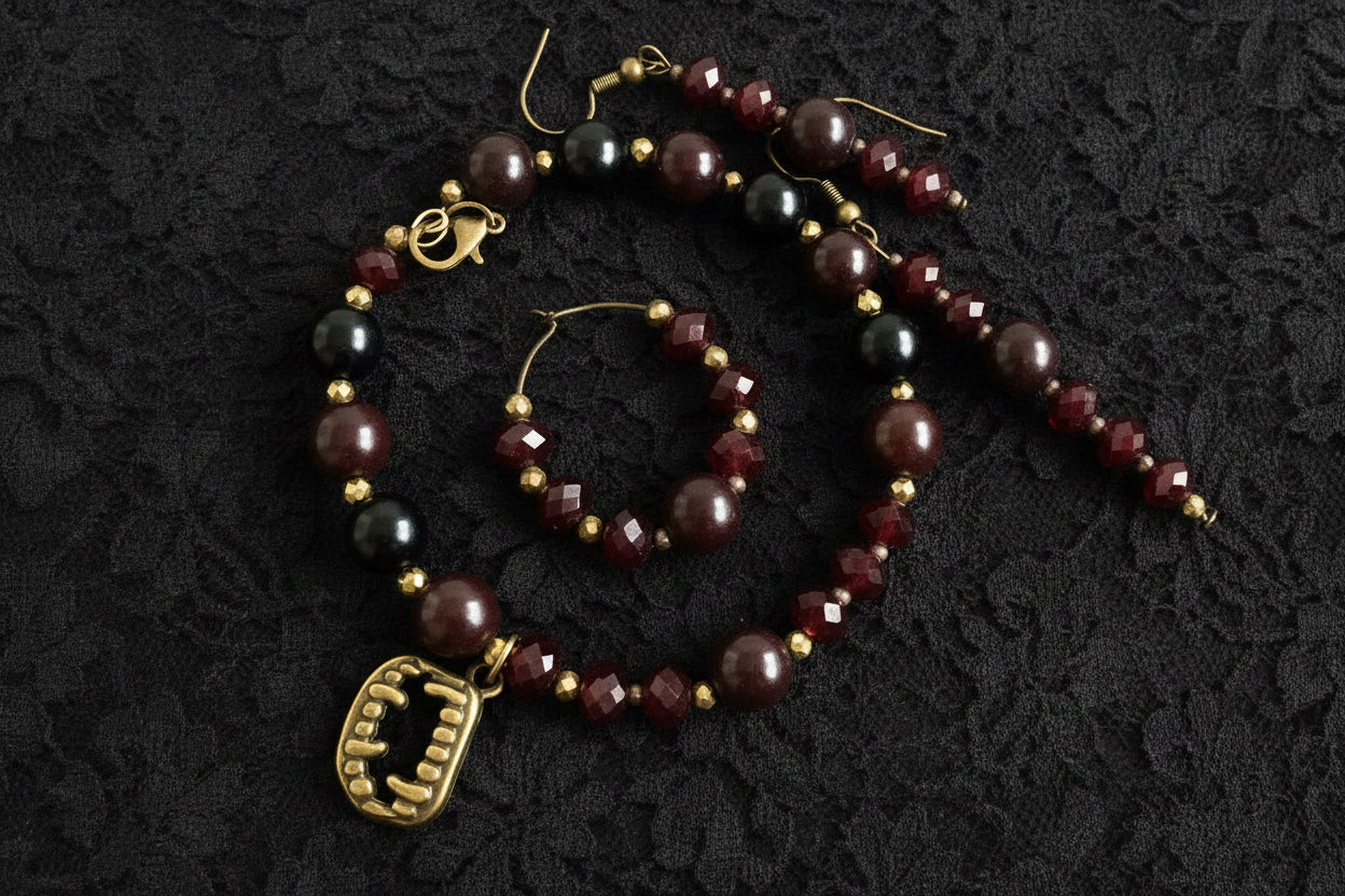 Beaded bracelet and earrings with a fangs charm on a black background
