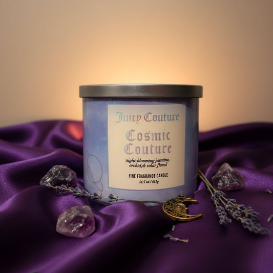 Luxury three wick candle with a purple tablecloth, flowers, and charms