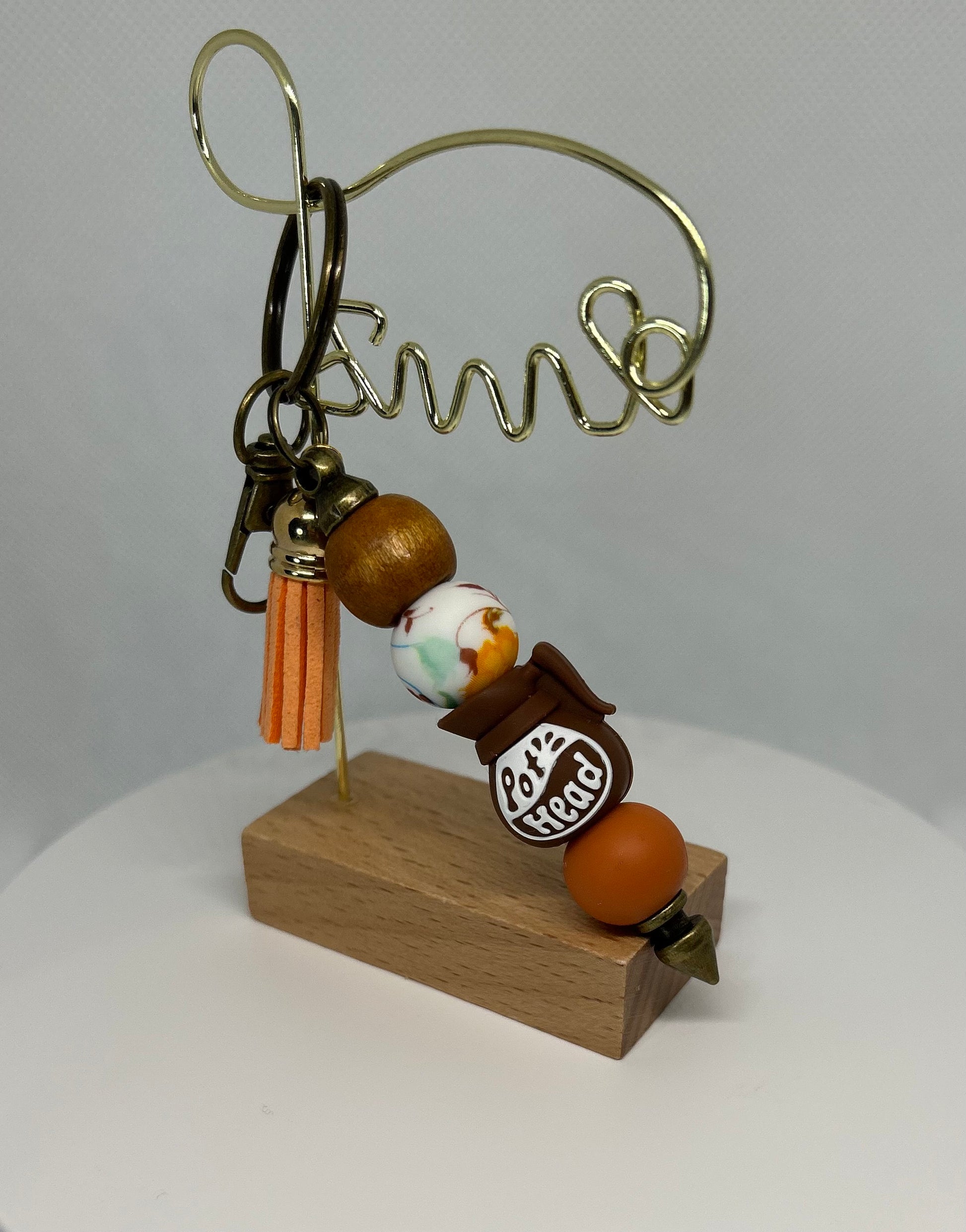 Decorative keychain with beads and a wooden base on a white background. Pot head bag charm. Pot head keychain. 